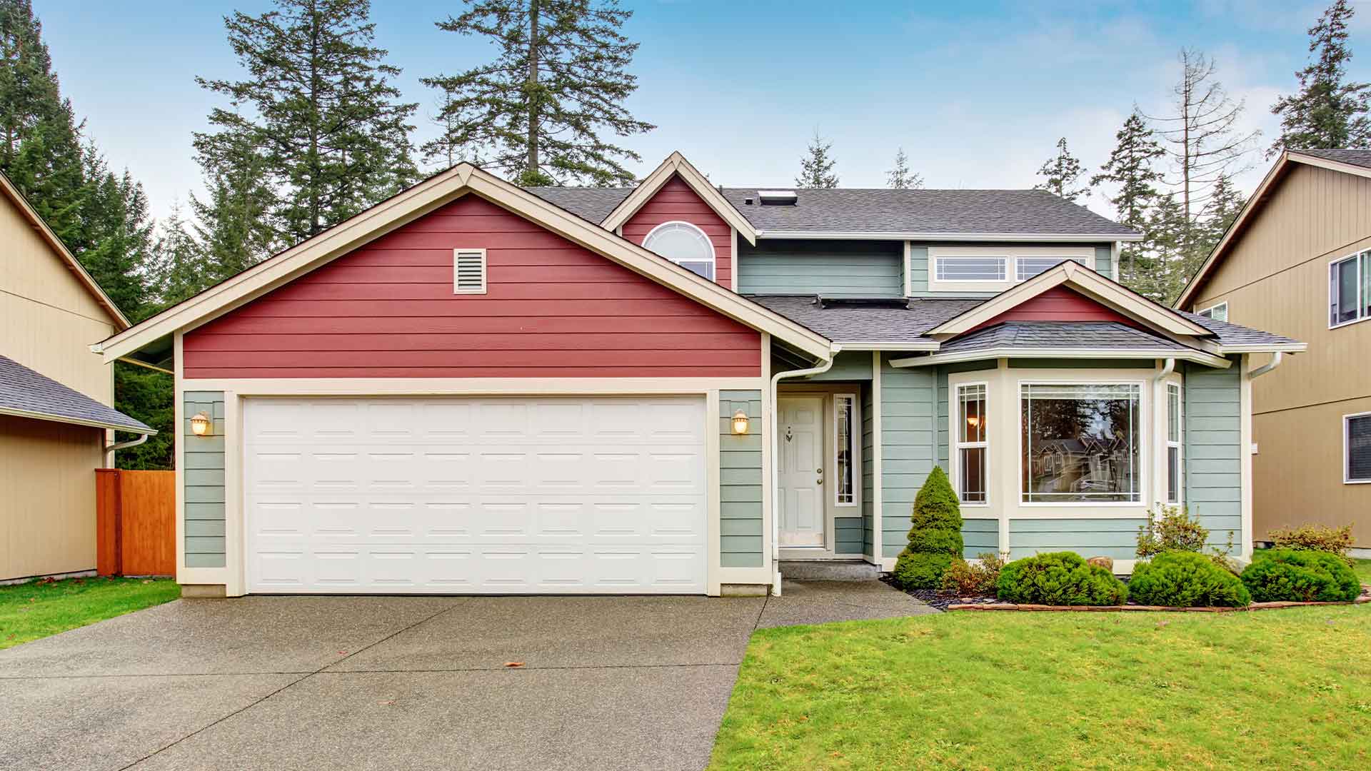 Quaint, blue and pink ranch-style home with a two-car garage in front