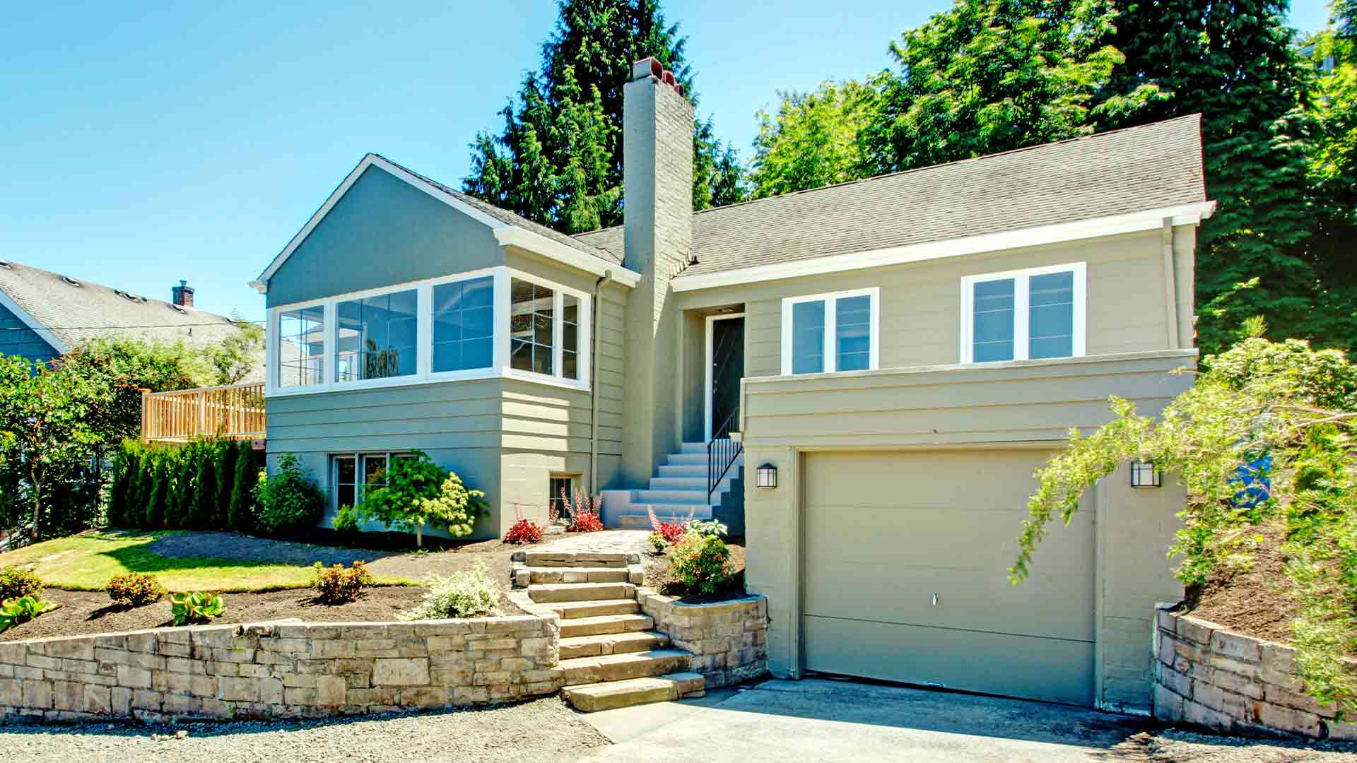 House exterior in clapboard siding with garage, driveway and front yard landscape