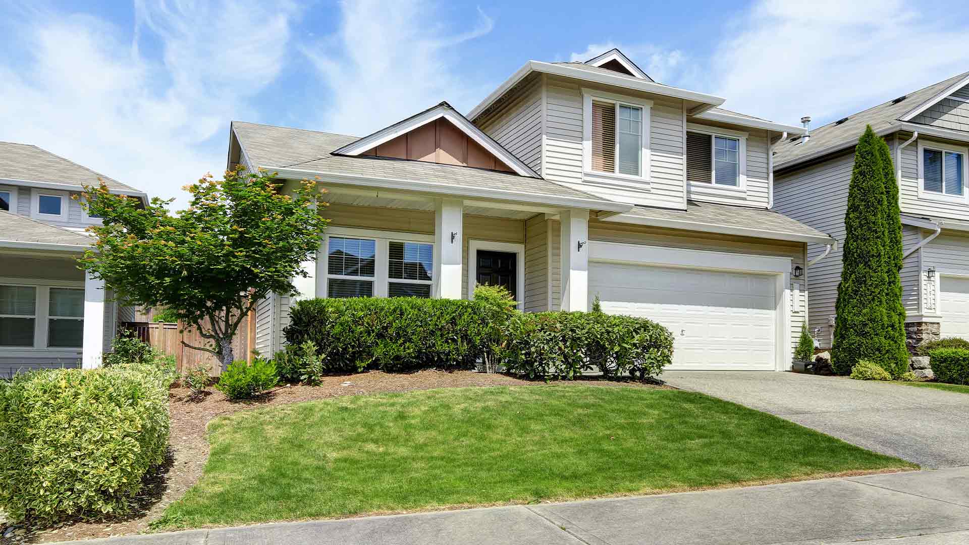 Exterior view of a two-story home with large front windows and a grassy lawn