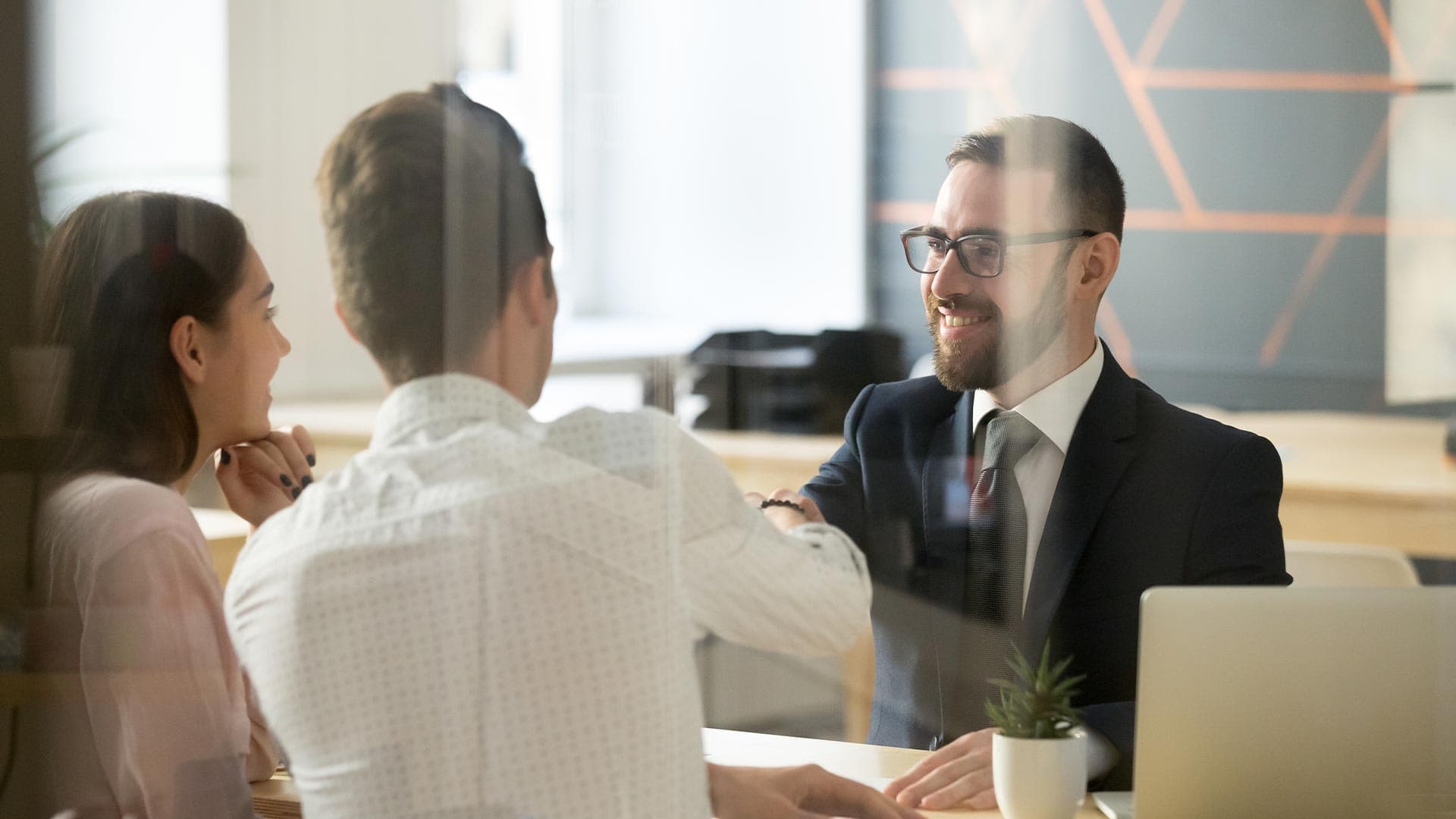 A couple at the bank shakes hands with their loan officer after getting a home equity loan