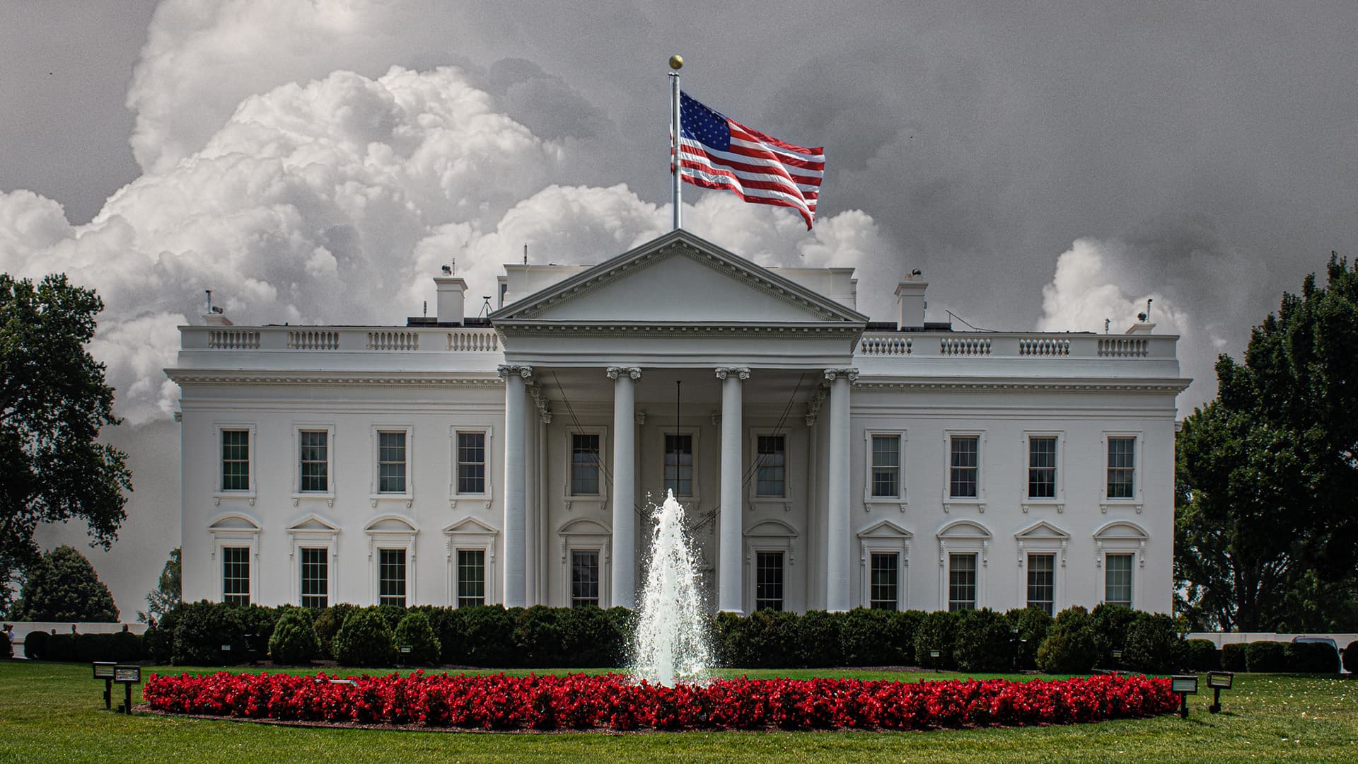 White House in Washington, D.C. with flag flying and fountain