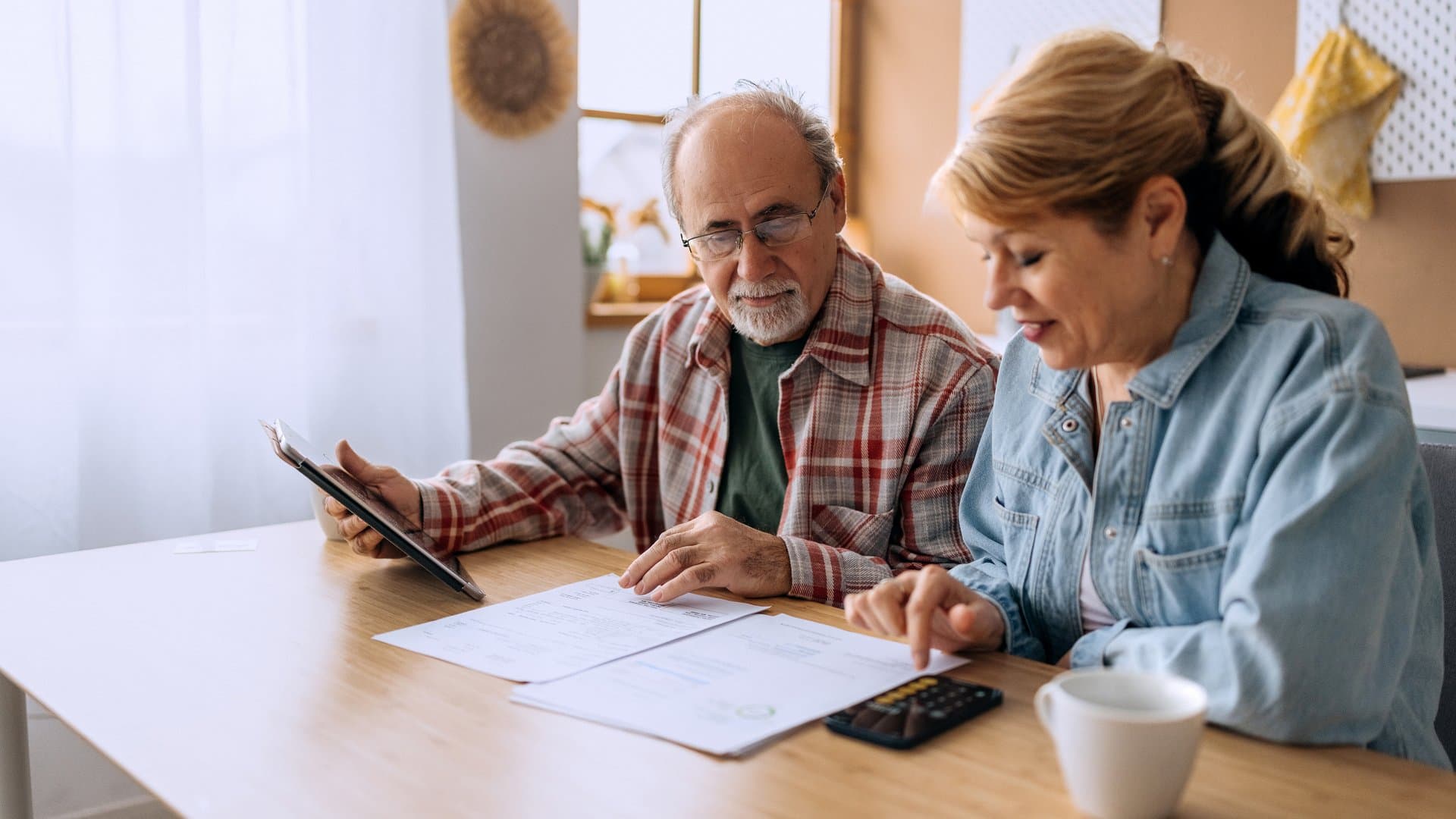 Senior couple reviewing home equity loan documents at kitchen table