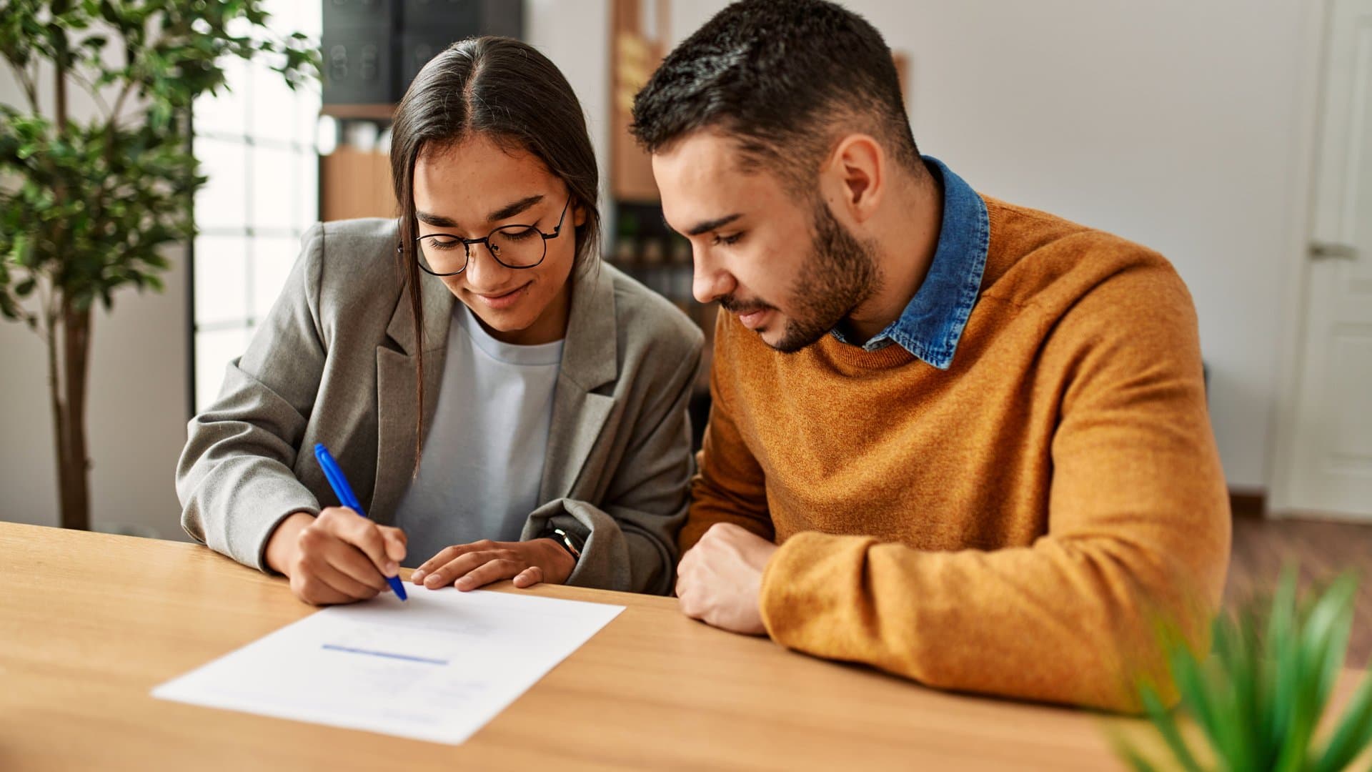 Couple signing home loan documents with a real estate agent
