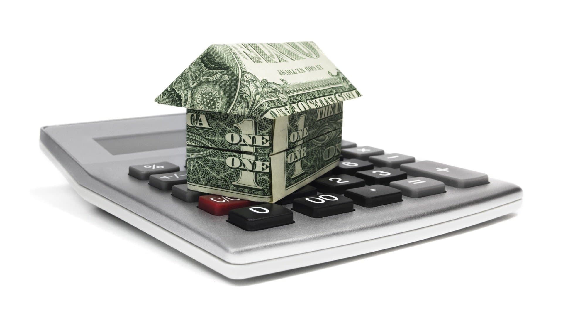 Calculator with origami house representing HELOC vs home equity loan comparison