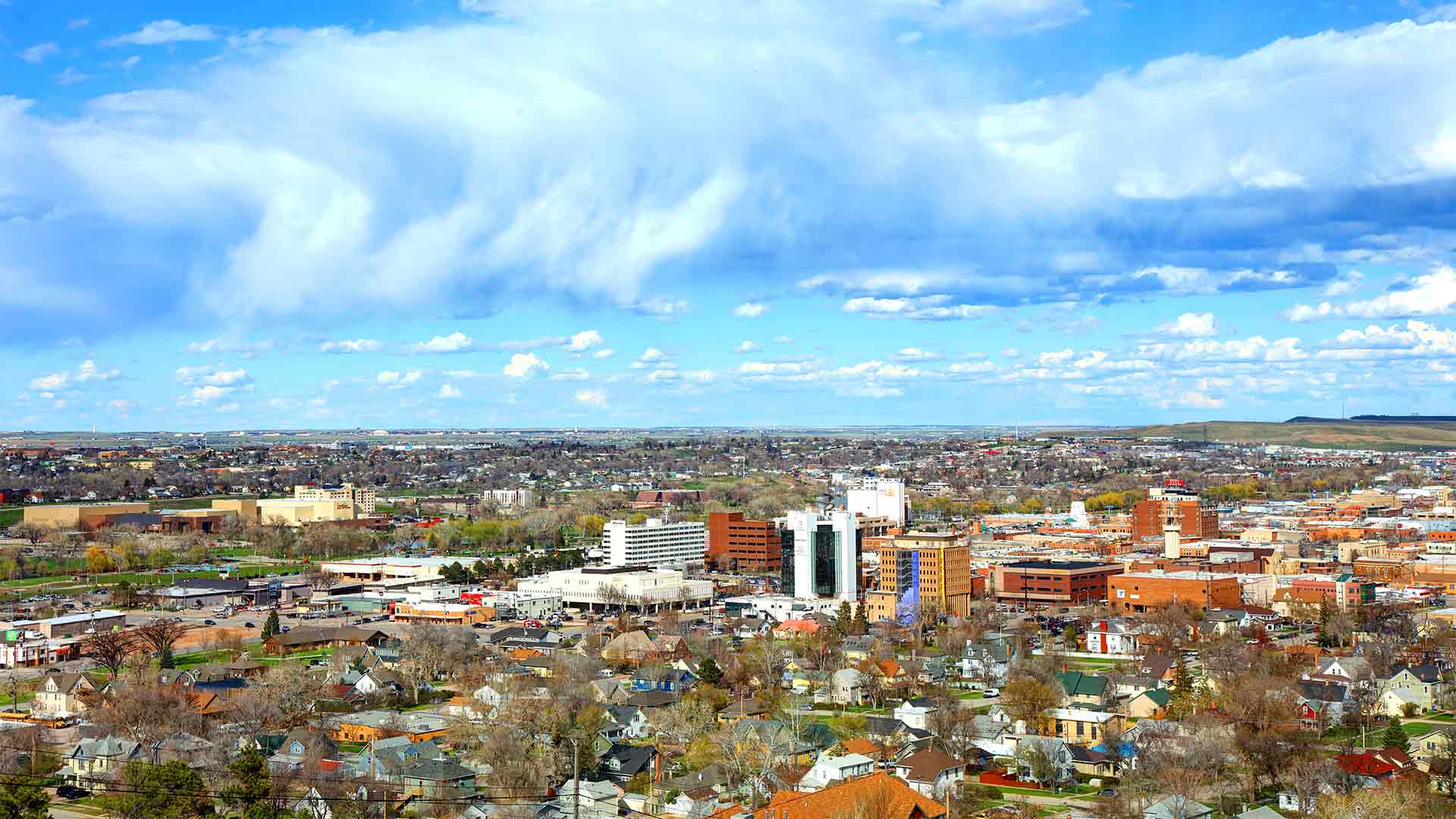 Aerial view of Rapid City, South Dakota set against a bright blue sky